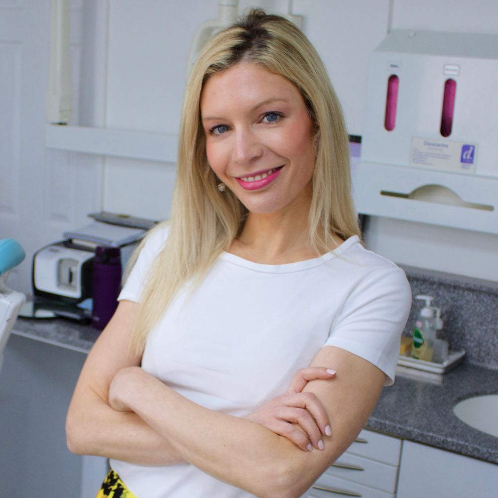 Founder and Principal Dentist, Dr Theodora Bravis, smiling in her clinic room at Thames Dental & Skin, in Thames Ditton, Surrey