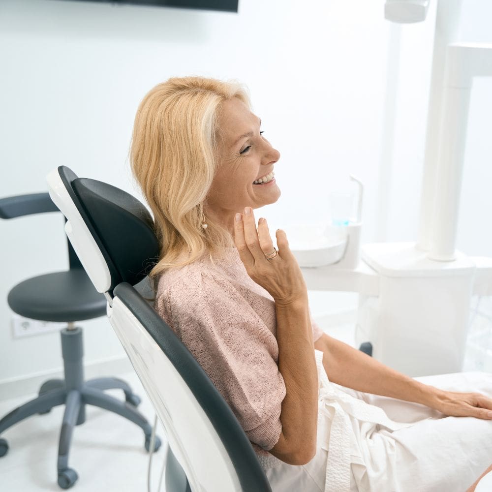 Mature blonde woman laughing during a skin consultation with Dr. Theodora Bravis at Thames Dental & Skin clinic in Thames Ditton, Surrey.