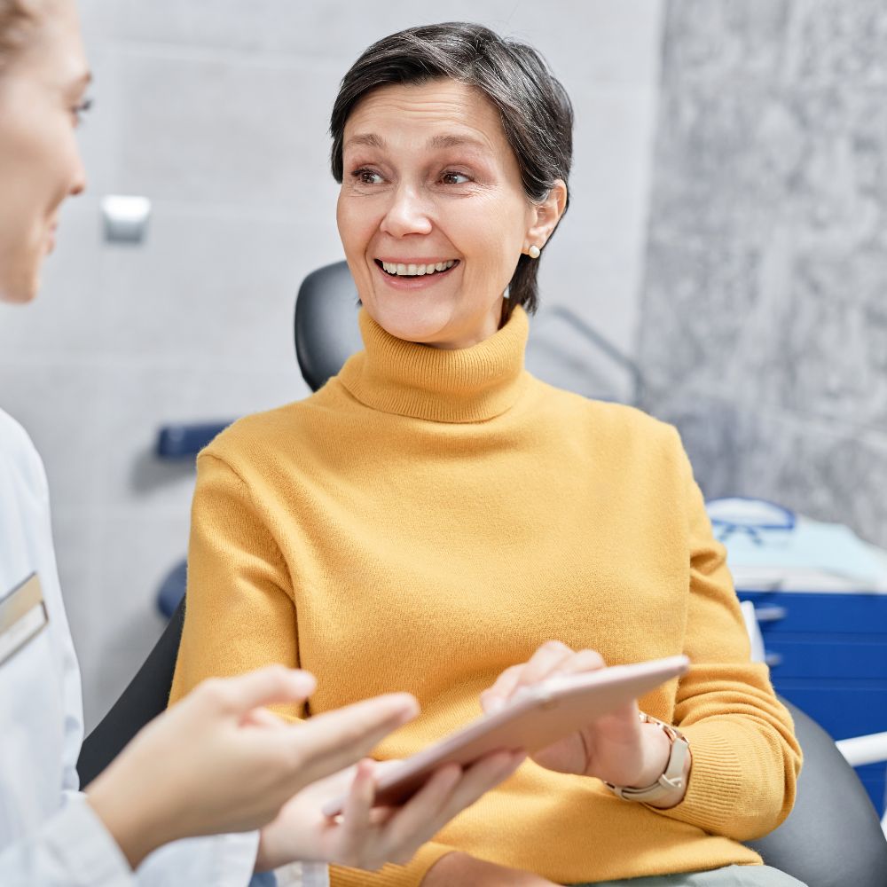 Mature woman having a dental implants consultation with Dr. Theodora Bravis at Thames Dental & Skin clinic in Thames Ditton, Surrey.