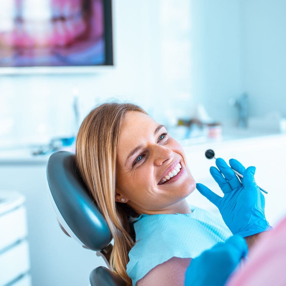 Dental hygienist at Dr. Theodora Bravis' Thames Dental & Skin clinic in Thames Ditton, Surrey cleaning and removing stains